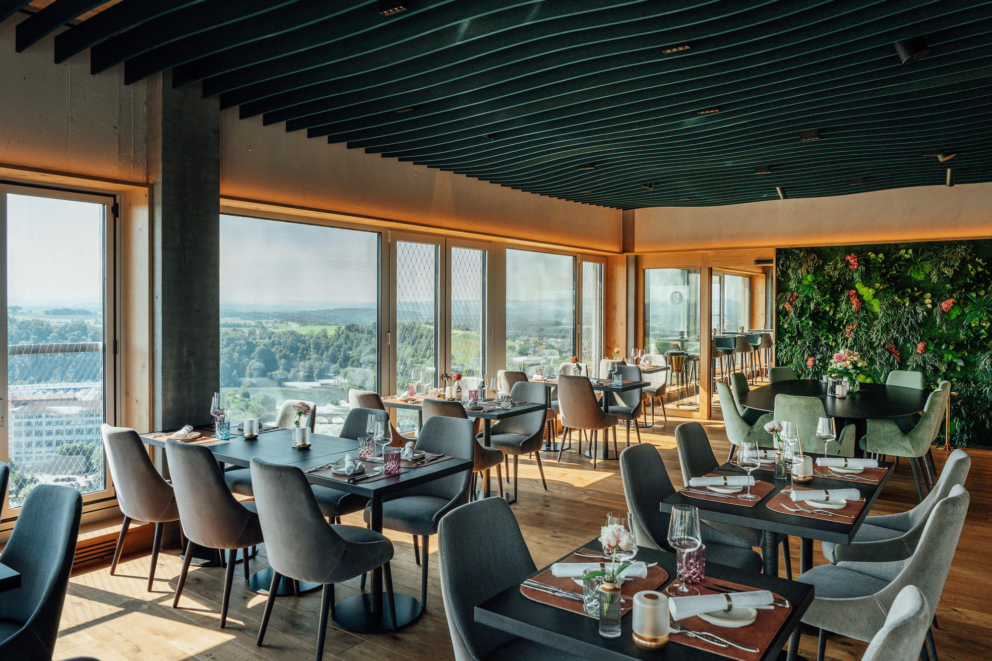 vitAcoustic Deckenbaffeln im Restaurant mit Panoramablick und Pflanzenwand